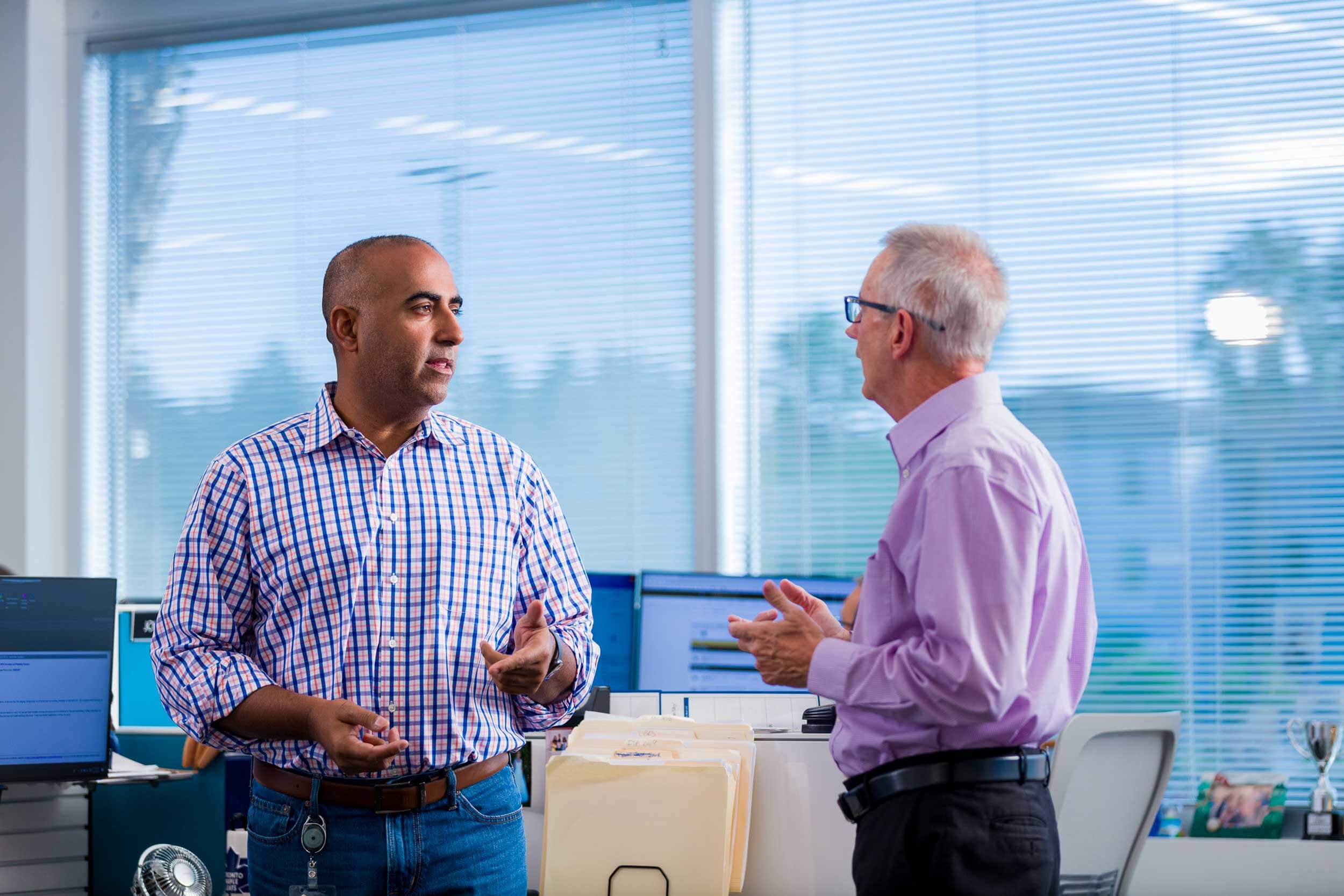 Two men standing in front of a window in their office in Florida