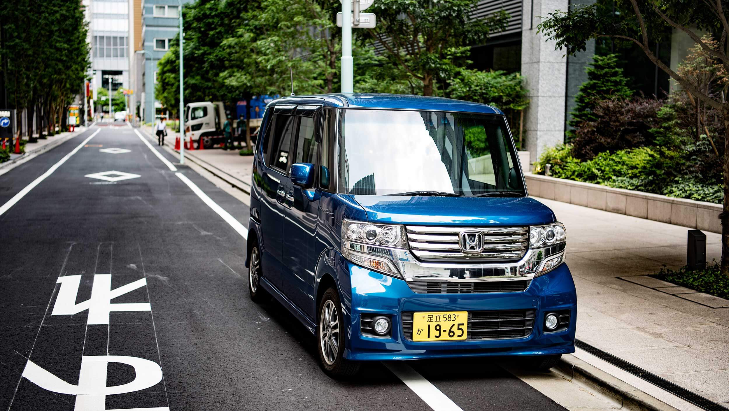 A blue truck parked on the side of a road