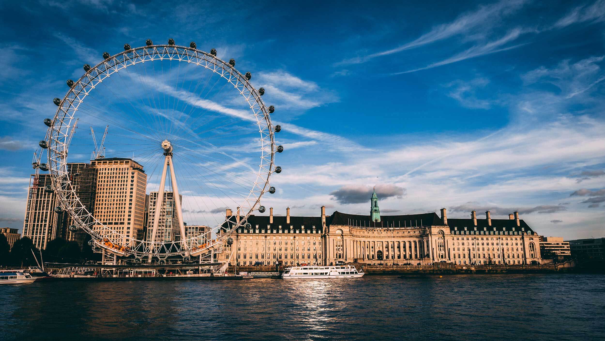 A large ship in the water with London Eye in the background