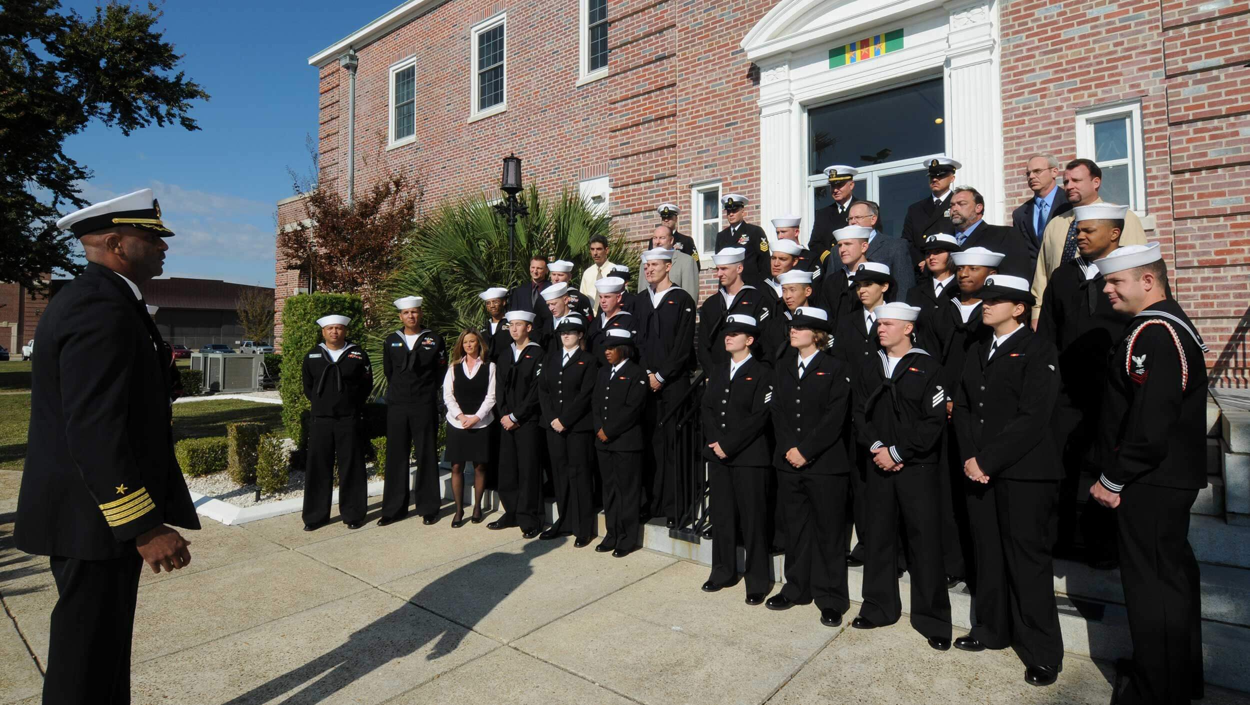 A group of people in uniform standing in front of a building