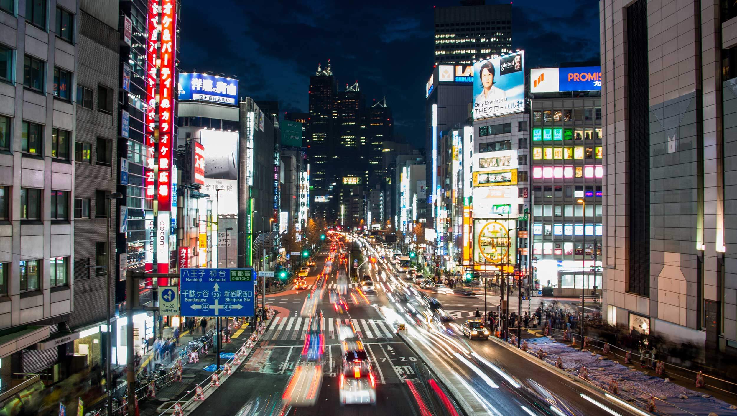 A close up of a busy city street with Times Square in the background