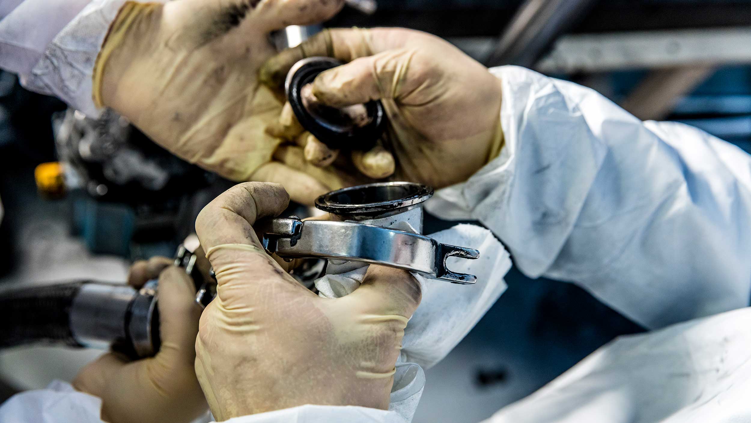 Gloved hands putting pieces of machinery together at a company in Forida