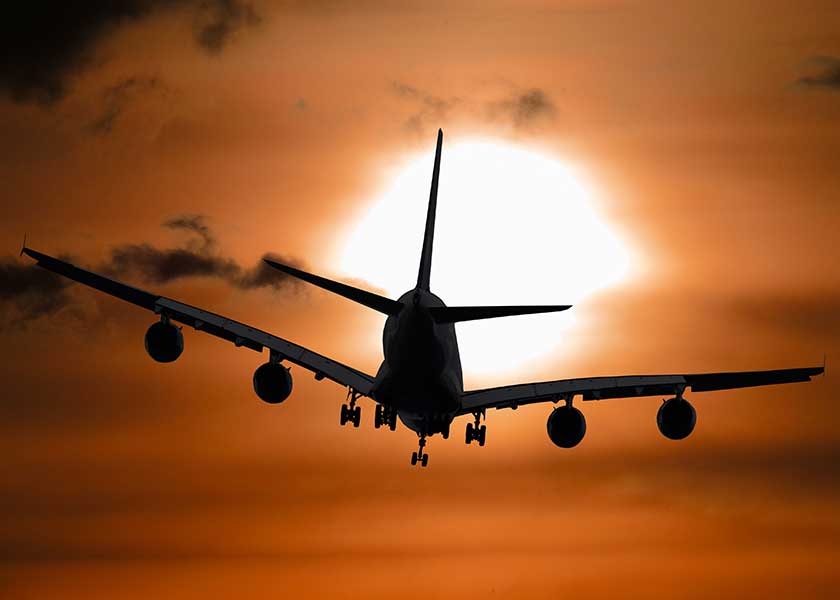 A large passenger jet flying through a cloudy sky